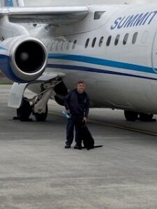 Paul Paquin with Ivy outside of plane Paul Paquin outside of plane with drug dog Ivy